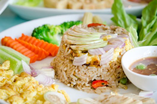 mixed cooked rice with shrimp paste sauce , fried egg and fresh vegetable , served with spicy chili sauce