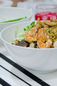 rice noodles with spicy pork and seafood sauce in white bowl, 