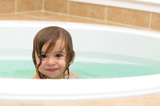 Cute Toddler giving satisfied look from the bath tub. Copy space on the right.