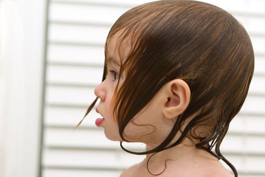 Wet haired toddlers side look, she have surprized, shocked moment, perhaps she saw the soap coming.