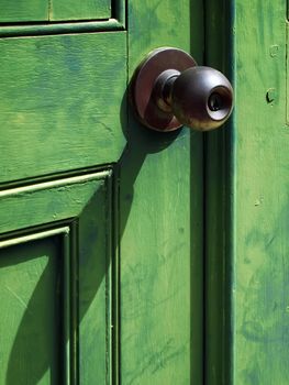 Old iron doorknob on Green wood door