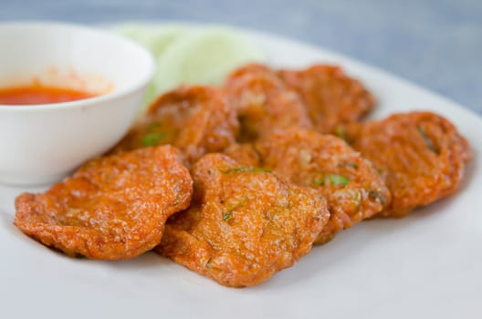 Spicy fried fish cake (Tod Mun Pla) served with cucumber  and  sweet sauce