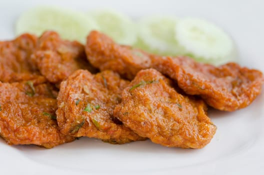 Spicy fried fish cake  served with cucumber on plate