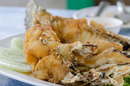 Fish dish - fried fish fillet with vegetables on white plate