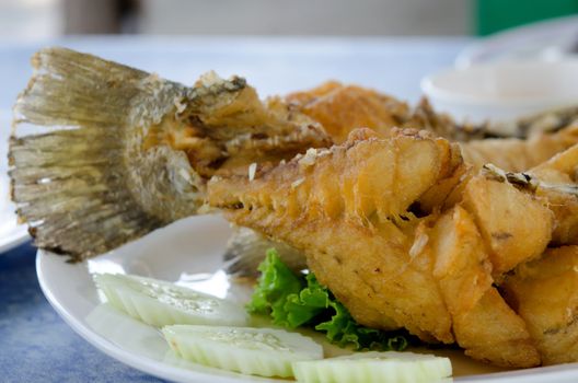  fried fish fillet with vegetables on white dish