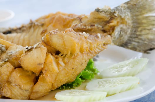 close up  fried fish fillet with vegetables on white plate
