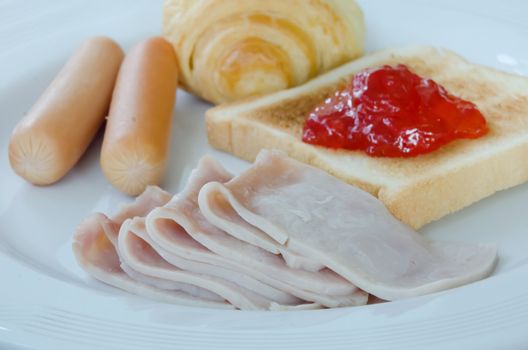 fresh  breakfast , with bacon, bread , sausage , toast and jam