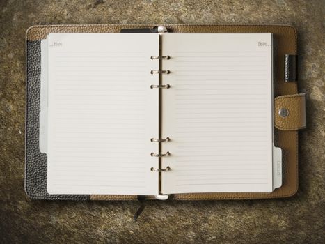 Black and brown leather cover of binder notebook on stone