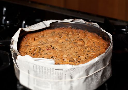 Traditional xmas cake straight from the oven and still wrapped in newspaper to allow it to bake slowly
