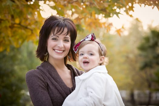 Attractive Mother and Daughter Portrait Outside at the Park.