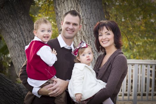 Young Attractive Parents and Children Portrait Outside in the Park.