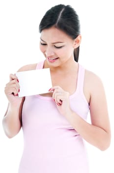 Portrait of young healthy woman holding and looking at blank card isolated on white background.