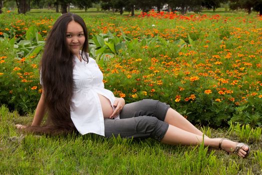 Young pregnant woman relaxing at a park