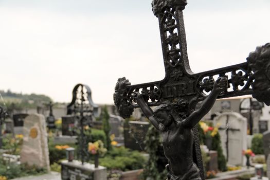 An almost falling cross in a rural cemetary in lower austria