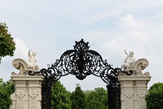 An iron gate flanked by in angels in castle Belvedere in Vienna, Austria