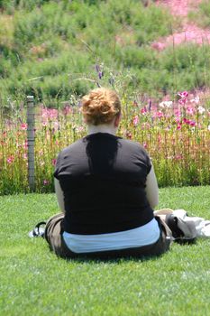 Overweight female sitting on the grass.