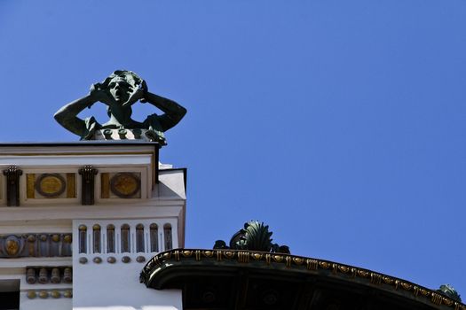 A sculpture of a screaming woman on top of an art building in Vienna, Austria