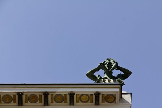 An art nouveau building with a screaming sculpture on top in Vienna