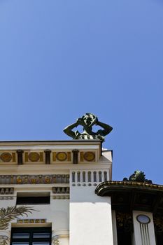 An art nouveau building with a screaming sculpture on top in Vienna