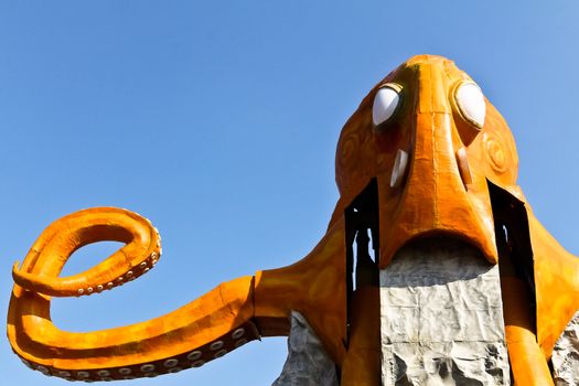 An orange octopus ride without passengers in an amusement park