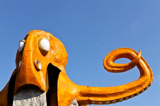 An orange octopus ride without passengers in an amusement park