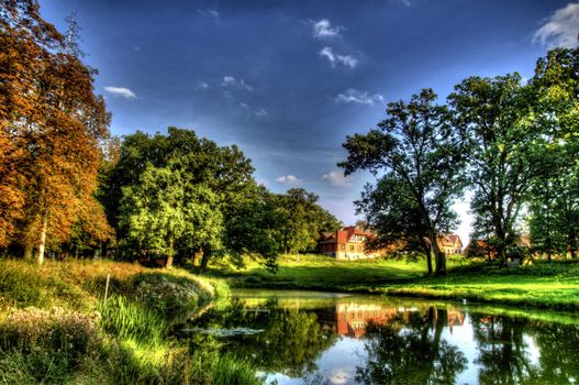 The photo shows a pond in a park, a place for walks and rest HDR.