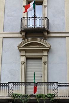 A closed balcony on a facade with italian flags