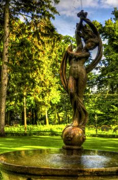 This photo present nymph on a fountain in the park HDR.