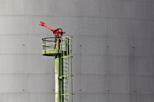 A fire extinguisher on an industrial area where oil and gas is stored