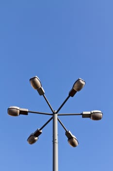 An old lamp post in Warsaw with 6 lights on it