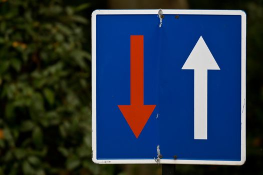 A grungy old sign saying that oncoming traffic has to wait in the center of Madrid