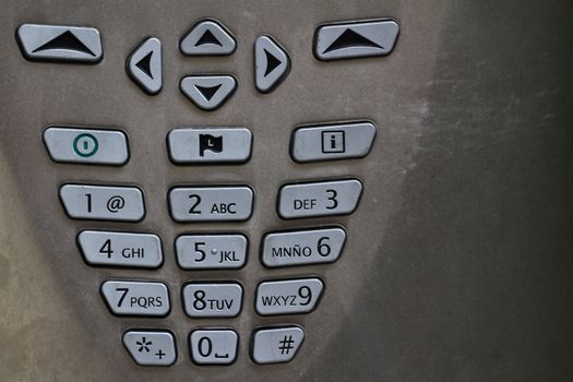 A spanish number pad of a public telephone