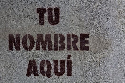 A stencil print on a public space in Madrid indicating "yout name here" in spanish