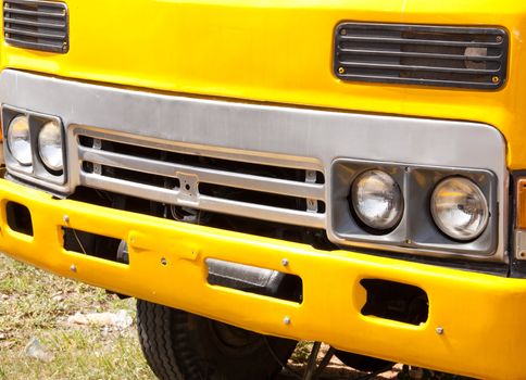 Front of the yellow truck parked on the road.