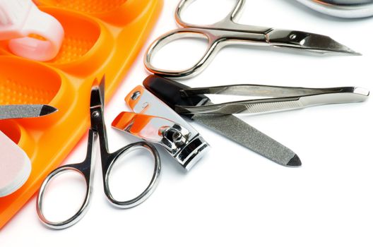 Manicure and Pedicure Set with Nail File, Tweezers, Scissors, Toe Divider and Other Accessories closeup on white background