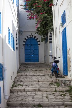 Narrow street with moped in Sidi Bou Said, Tunisia