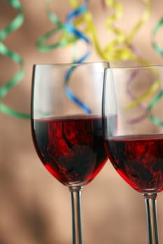 Red wine with curled ribbons on the background.