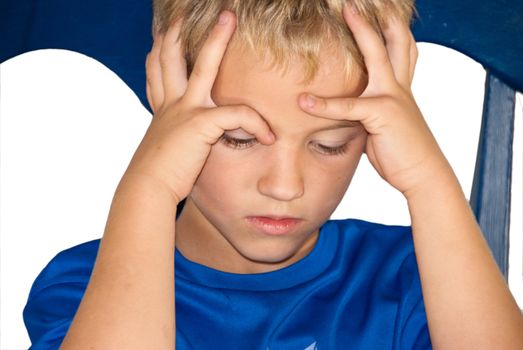 Little boy sitting in a chair pouting with this hands on his head and frown on his face.