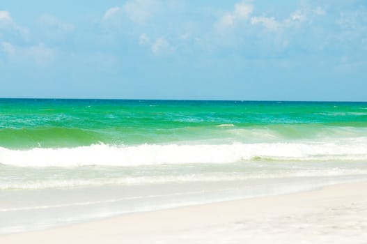 A beautiful view of the aqua blue ocean from the sandy beach.