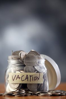 Jar labeled vacation filled with money.