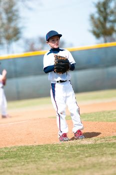 Little league baseball pitcher getting ready to throw the ball.