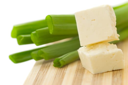 Cubed cheese with green onion on a kitchen counter 