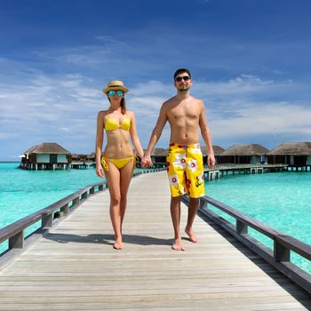 Couple on a tropical beach jetty at Maldives