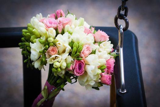 Wedding bouquet with roses and freesia on rustic country fence
