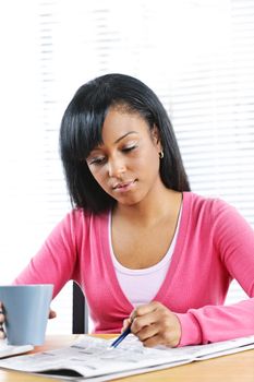 Young black female student looking in newspaper for job