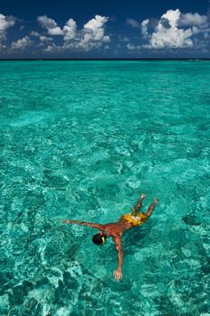 Man snorkeling in crystal clear turquoise water at tropical beach