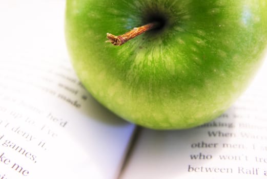 close up of an apple on opened book