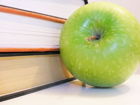 green apple with books