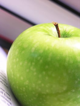 close up of an apple on opened book