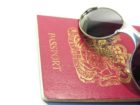 close up of passport and sunglasses in white background